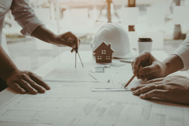 Stadtplanung Quereinstieg: Zwei Stadtplaner arbeiten gemeinsam an Planzeichnungen für ein Stadtentwicklungsprojekt.
