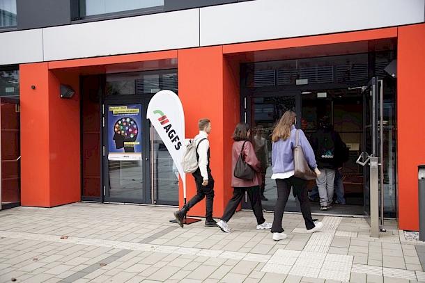 Studierende laufen in die Universität zu einer Infoveranstaltung von PLANE DEINE STADT!