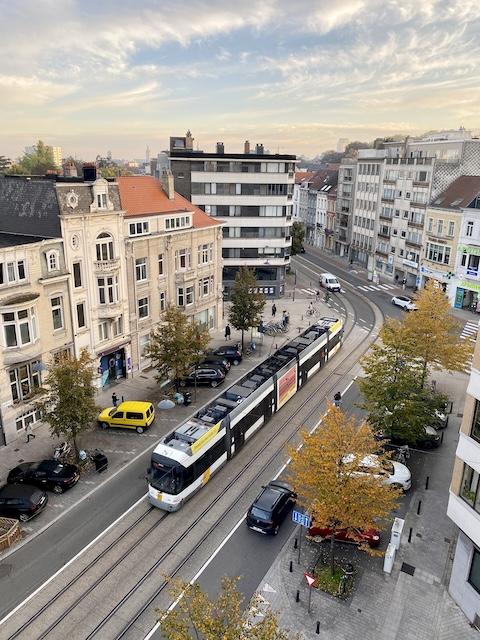 Eine Straße auf der die Straßenbahn und Autos Fahren und zwei Zebrastreifen zu sehen sind