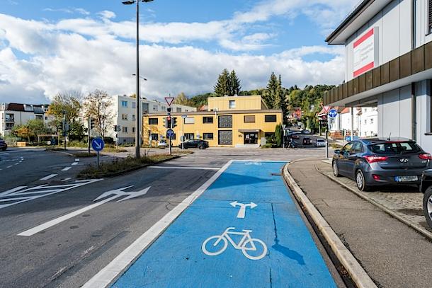 Eine Straße mit einem blauen Fahrradweg, bei dem man in beide Richtungen abbiegen kann.